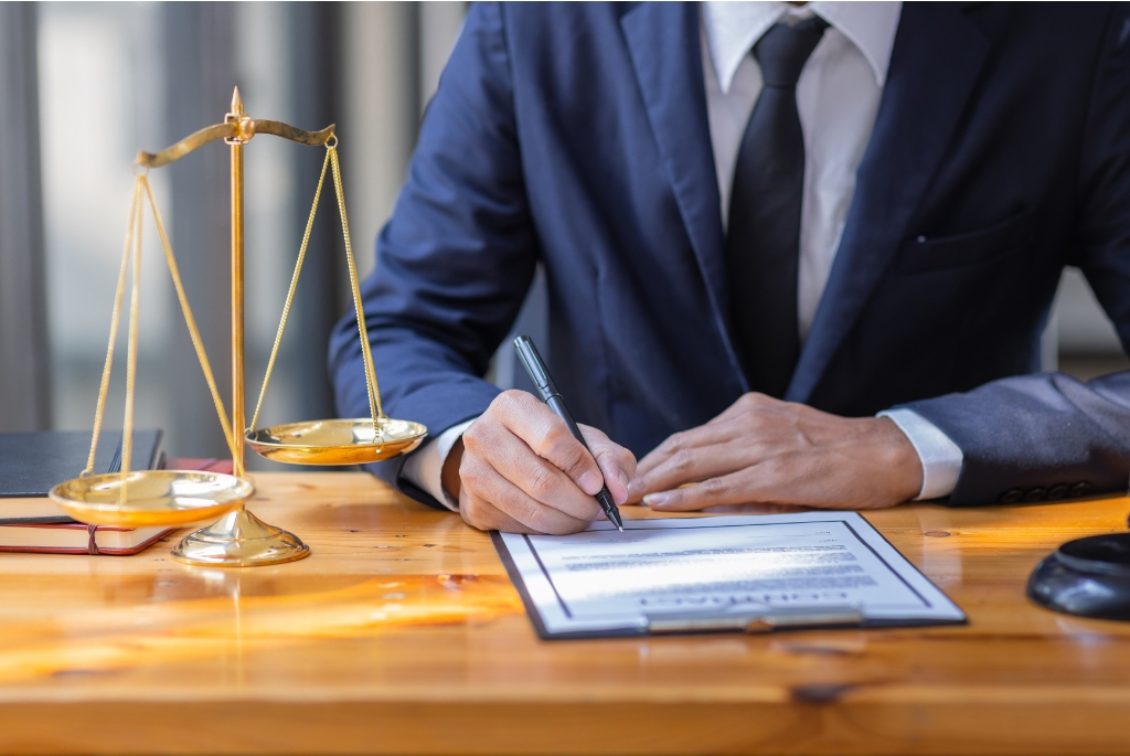 Legal Consultant Writing Contract Documents at Desk